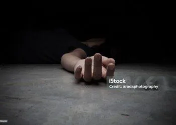 The dead woman's body. Focus on hand